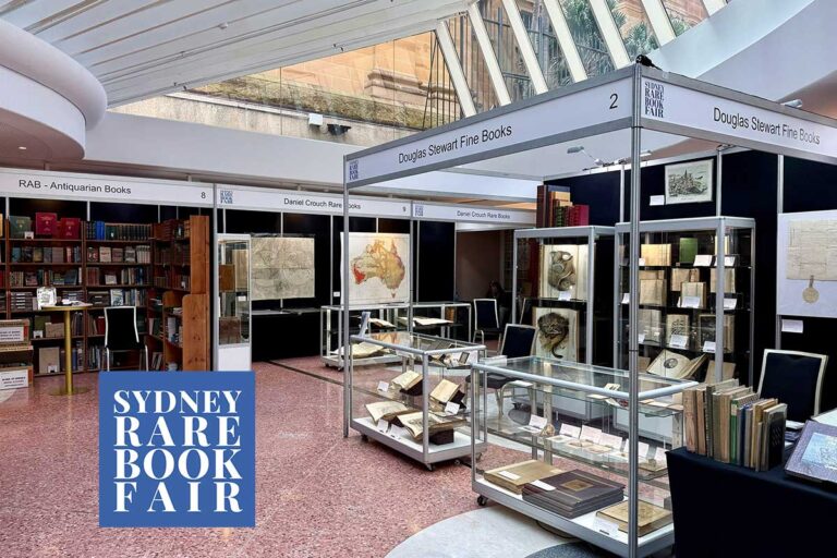 Exhibitor stands and glass display cases beneath the skylit Glasshouse atrium at the Sydney Rare Book Fair, State Library of NSW.