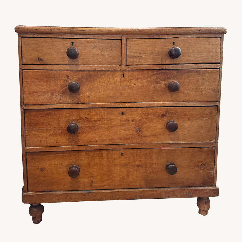Mid-1800s English country house pine five drawer chest on turned feet.