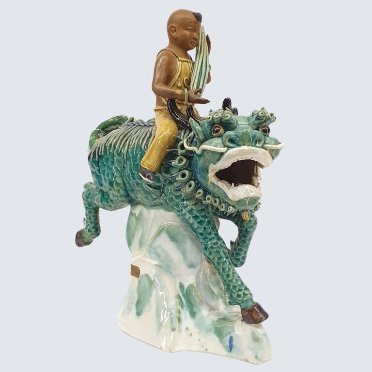 A Chinese Shiwan polychrome Pottery group depicting Budai riding a Kirin, gilt seal mark to base. 20th century.