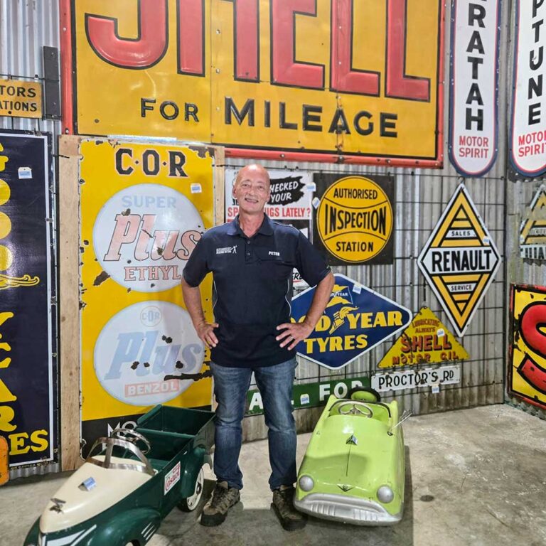 Peter Economos of Roadhouse Collectables Auctions with enamel signs and vintage pedal cars