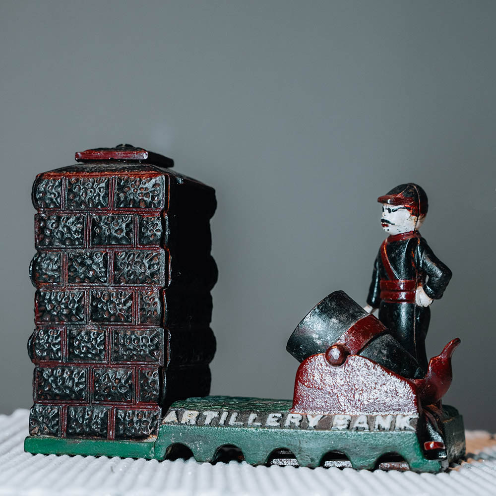An antique mechanical ‘Artillery Bank’ cast iron money box