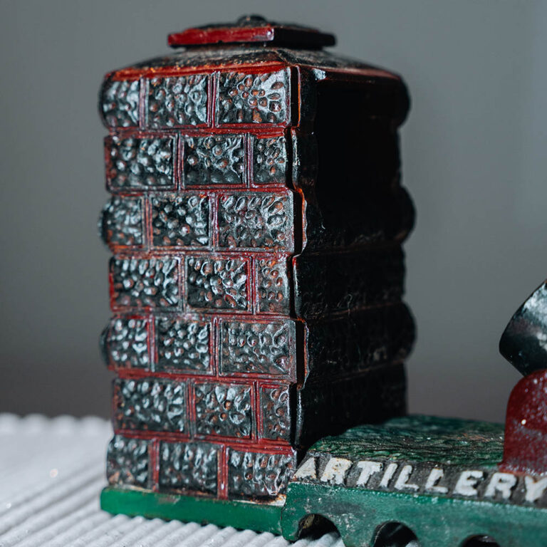 An antique mechanical ‘Artillery Bank’ cast iron money box