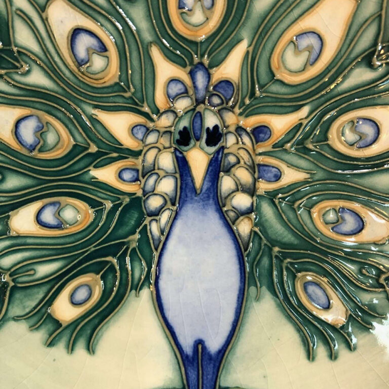 Moorcroft pottery plate with an elegant peacock