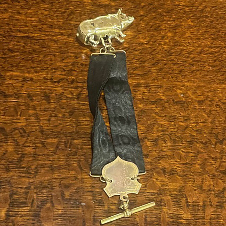 Black grosgrain silk ribbon c.1880-1910, attached to T-bar and a novelty pig