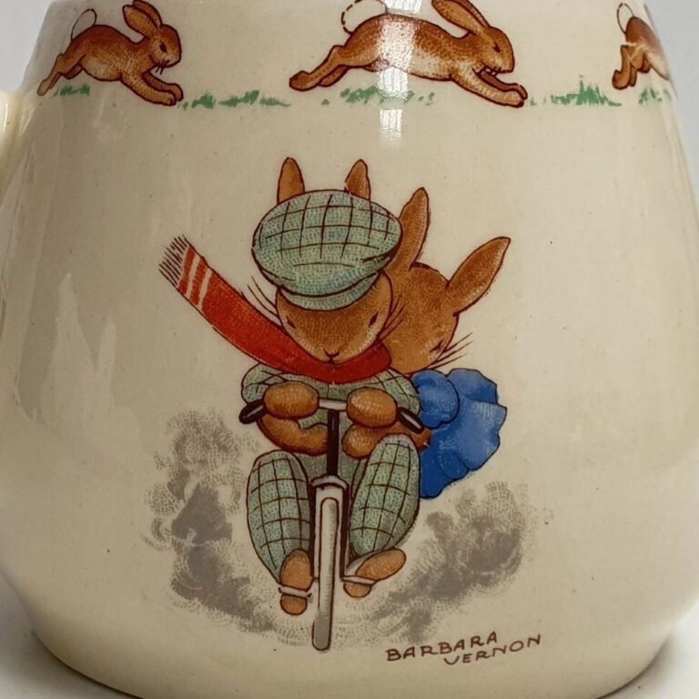 A Royal Doulton Bunnykins mug designed by Barbara Vernon, Gardening /Cycling. Don shape c.1937-53.