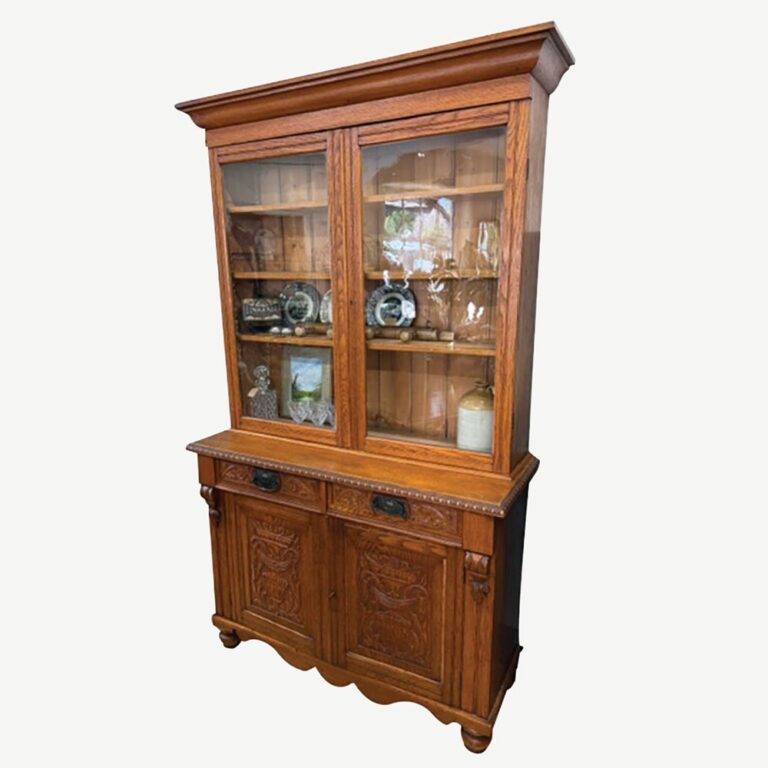 A lovely English oak glass top Victorian bookcase c.1880s with two carved drawers and two carved doors to a base on turned feet.