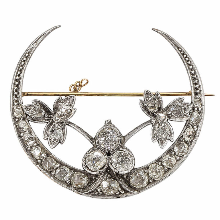 A Victorian brooch set with diamonds, gold and silver in a delicate half moon design with flowers