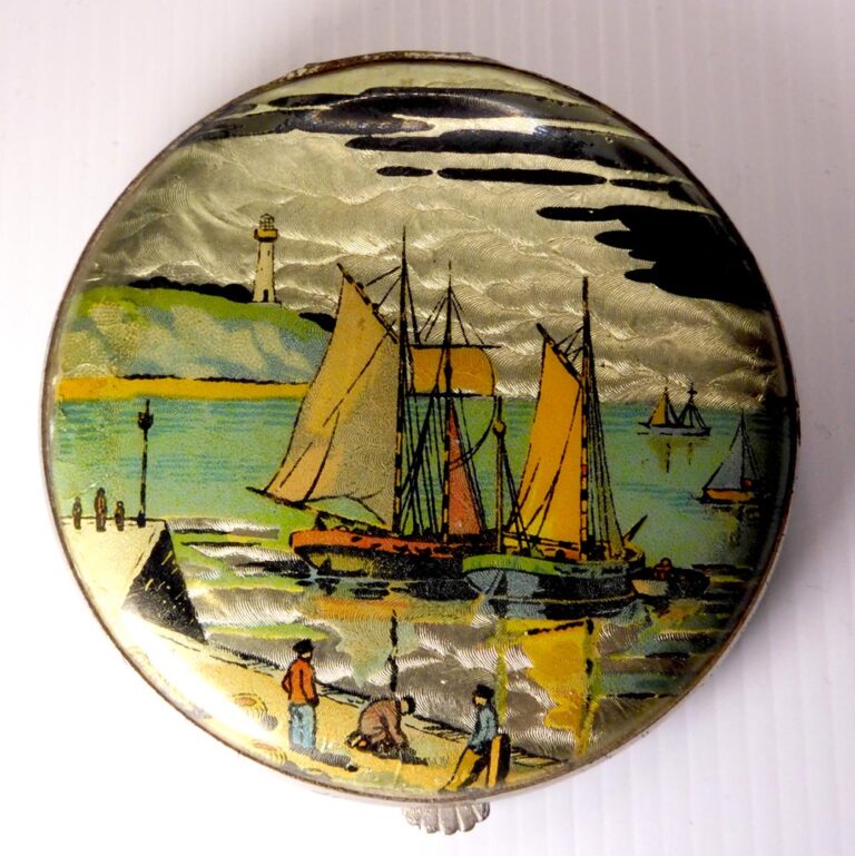 A vintage compact with a tin foiled back and a charming seaside print.