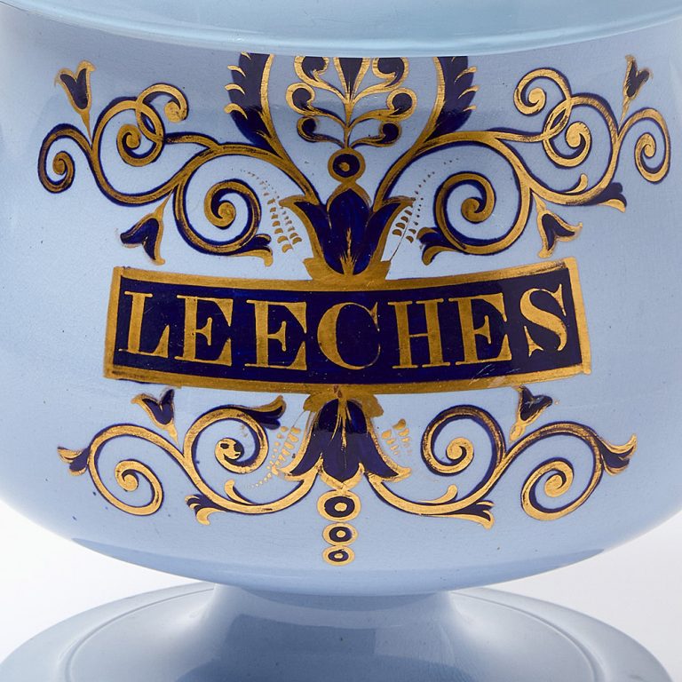 A pale blue glazed leech jar with gilt lettering and decoration