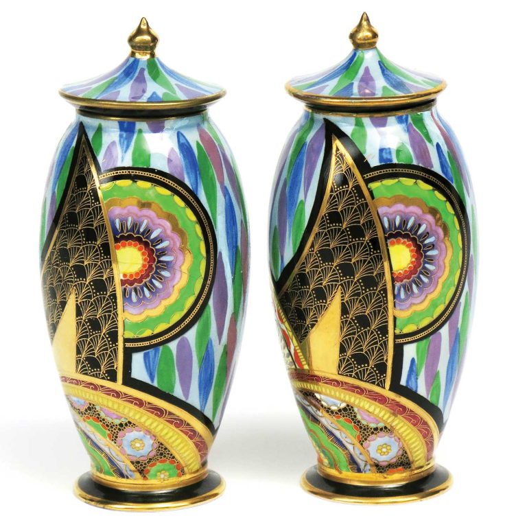 A pair of Scimitar covered vases, 18.5cm high, enamelled in geometric fan and floral form patterns with elaborate gilding on a purple and green repeating leaf form ground.